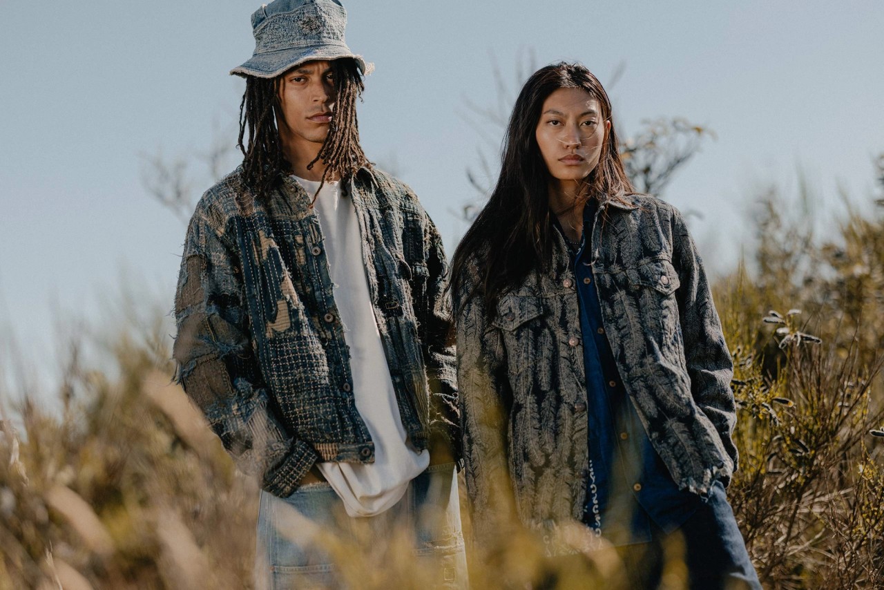 Man and woman standing in a field wearing Kapital BORO denim jacket and KAPITAL Feather Jacket